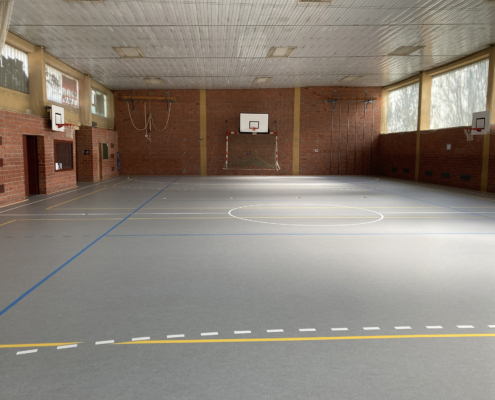 Blick in die Sporthalle mit dem neuen flächenelastischen Boden. Die Linien- und Spielfeldmarkierungen sind bereits aufgebracht.