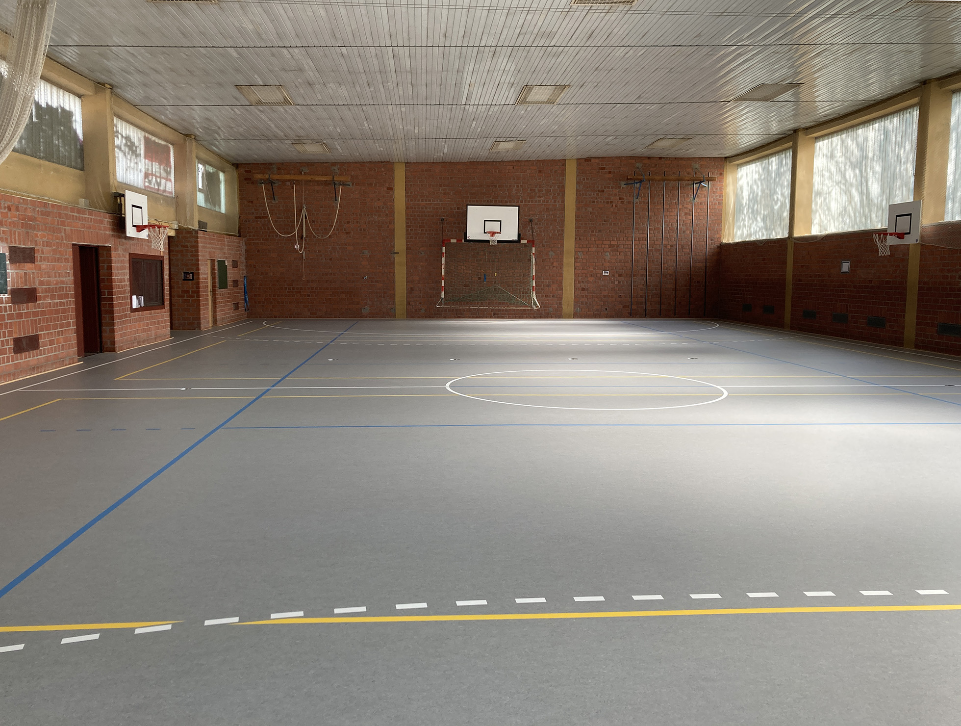 Blick in die Sporthalle mit dem neuen flächenelastischen Boden. Die Linien- und Spielfeldmarkierungen sind bereits aufgebracht.